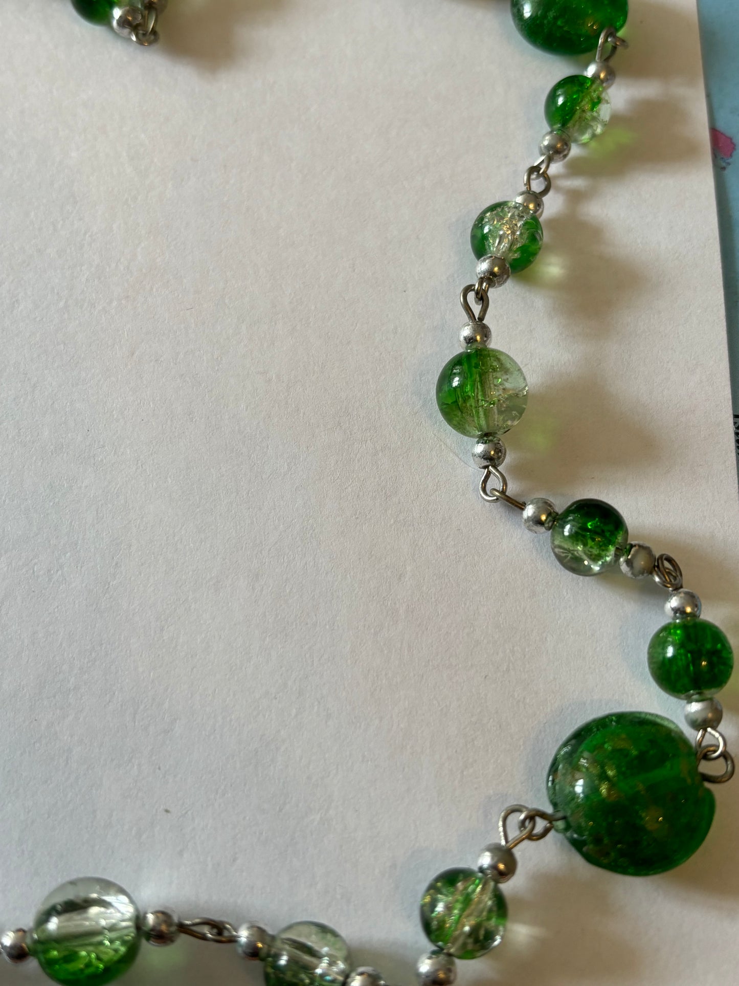 Long silver necklace with green spaced beads