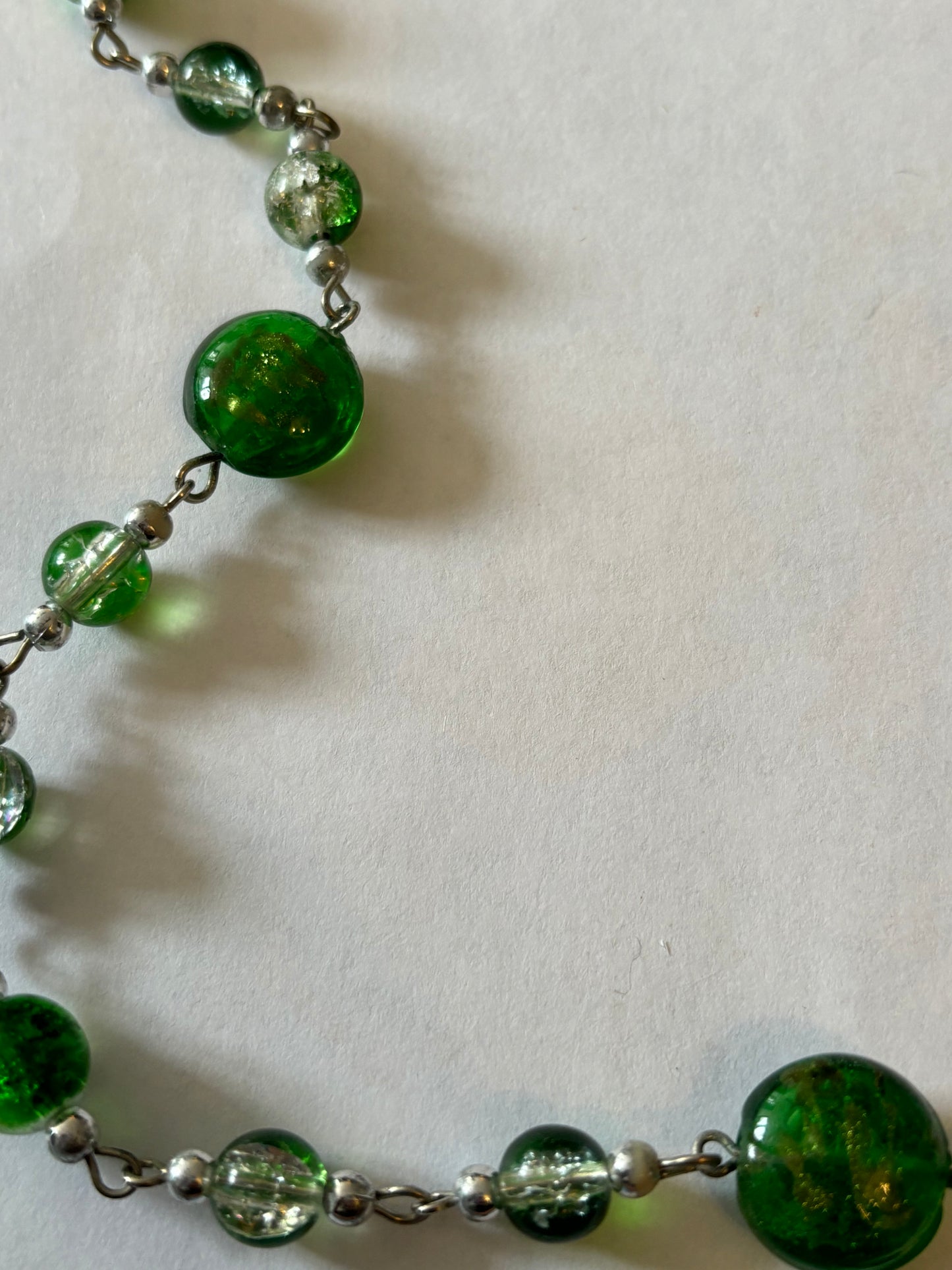 Long silver necklace with green spaced beads