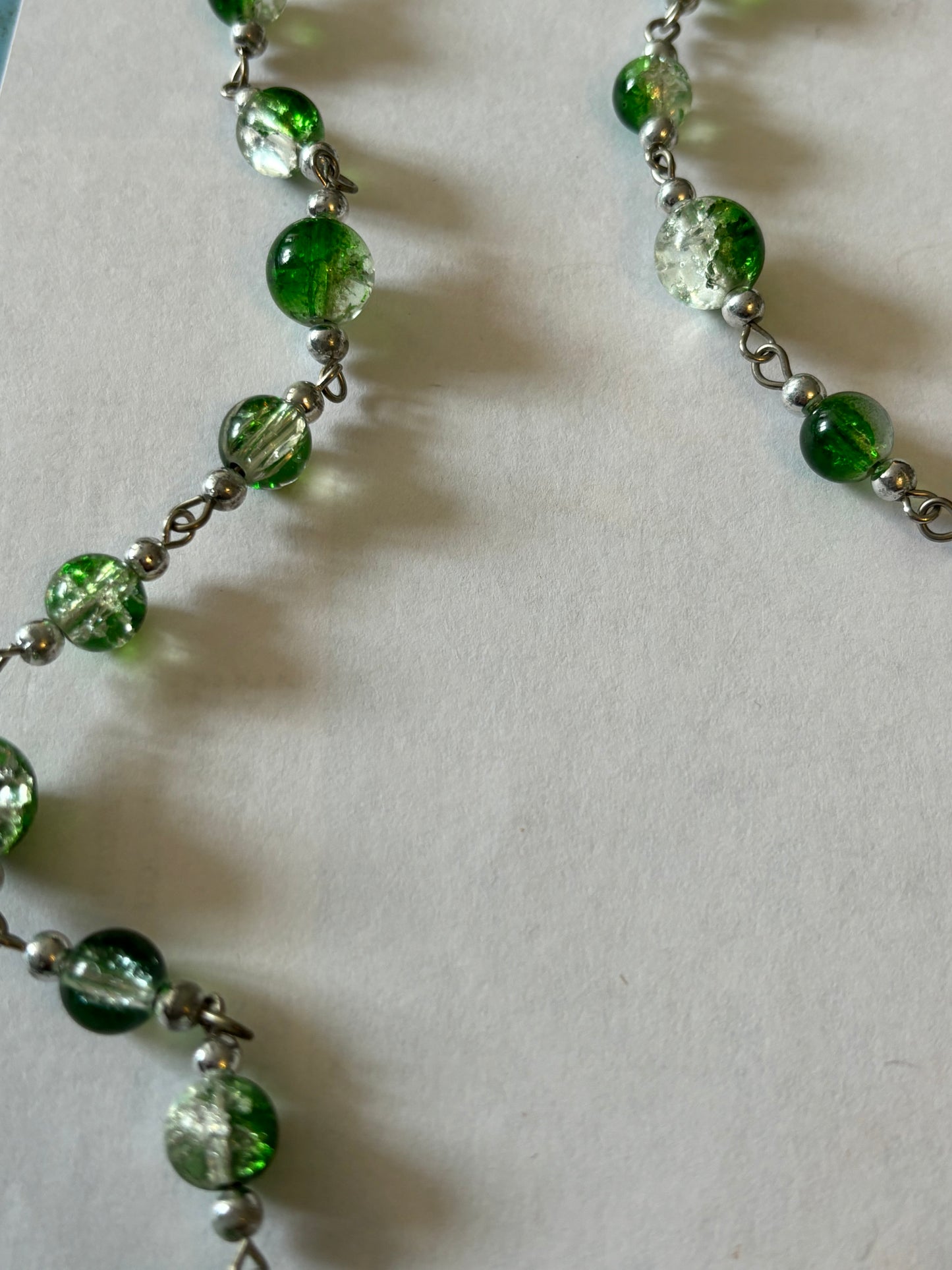 Long silver necklace with green spaced beads