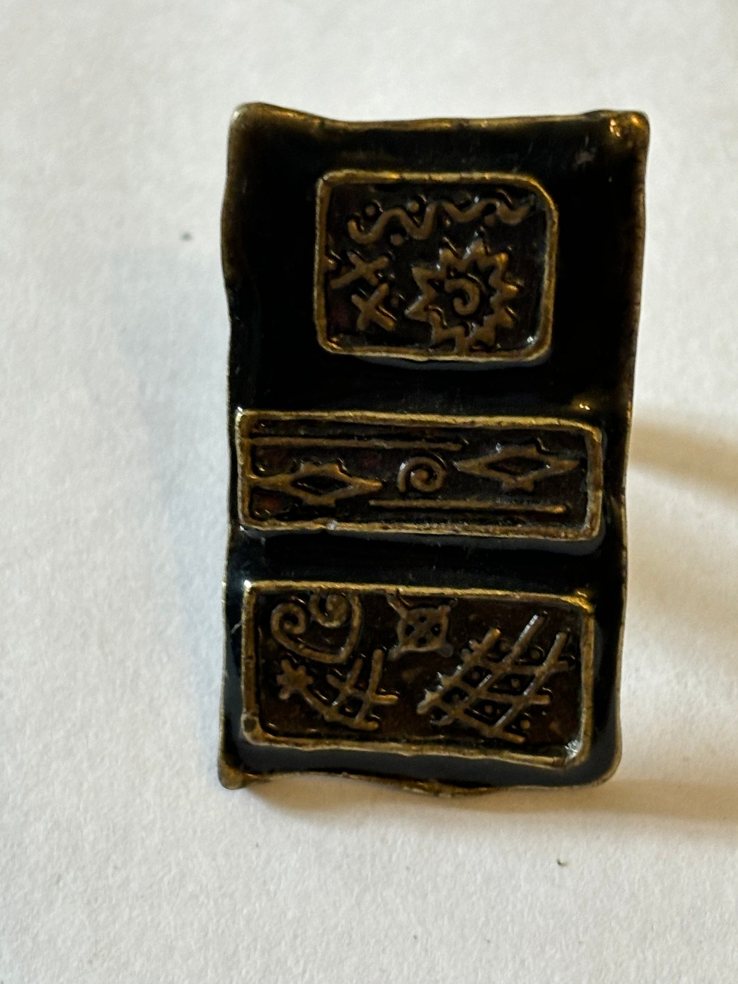 Dark metal ring with large rectangular flat patterned top