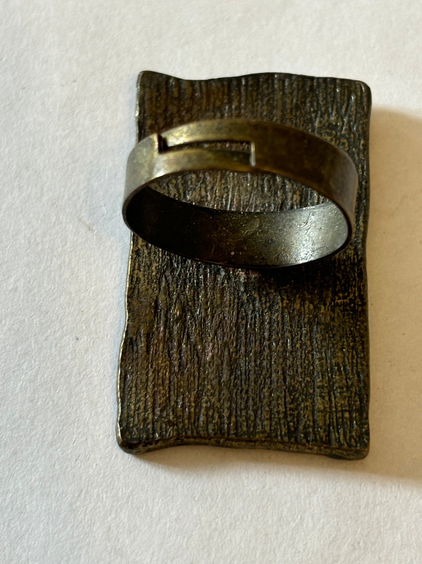 Dark metal ring with large rectangular flat patterned top